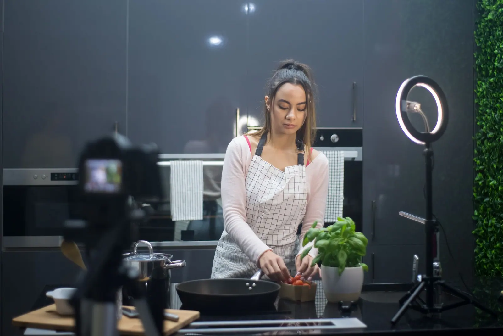 A young woman preparing a meal in a modern kitchen, filmed under professional lighting. How to approach best campaign briefs tools in practice