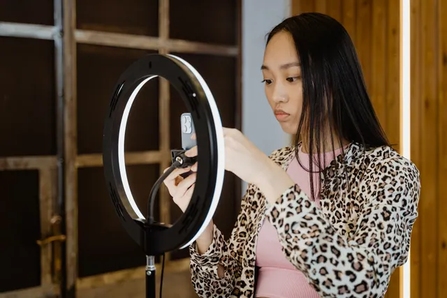 Asian woman with leopard print jacket adjusts ring light for smartphone streaming setup. Is signature really the hard part of a disclosure record?