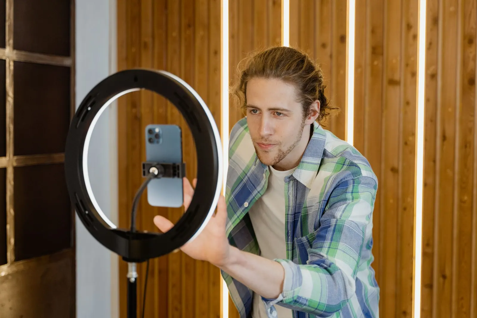 A young man sets up a smartphone and ring light for social media video recording, focusing on optimal lighting. How to judge contracts and disclosure tools before you commit