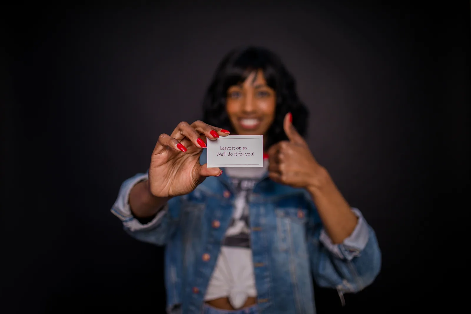 Smiling woman holding a business card with a message in focus, thumbs up sign. What creator outreach tools actually deliver beyond the message