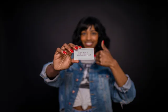 Smiling woman holding a business card with a message in focus, thumbs up sign. What creator outreach tools actually deliver beyond the message