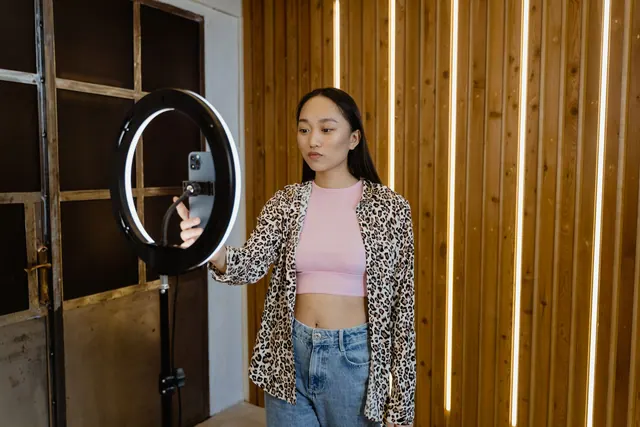 An asian woman influencer filming a vlog with a ring light in a stylish indoor setting. Contracts and disclosure: facts, examples and context