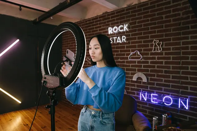 Asian woman influencer sets up a ring light in a neon-lit room for content creation. Contracts and disclosure checklist for the careful reader for 2027
