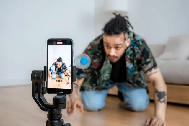 Man filming creative content with smartphone on gimbal indoors. Influencer discovery gets cheaper when you qualify in the right order